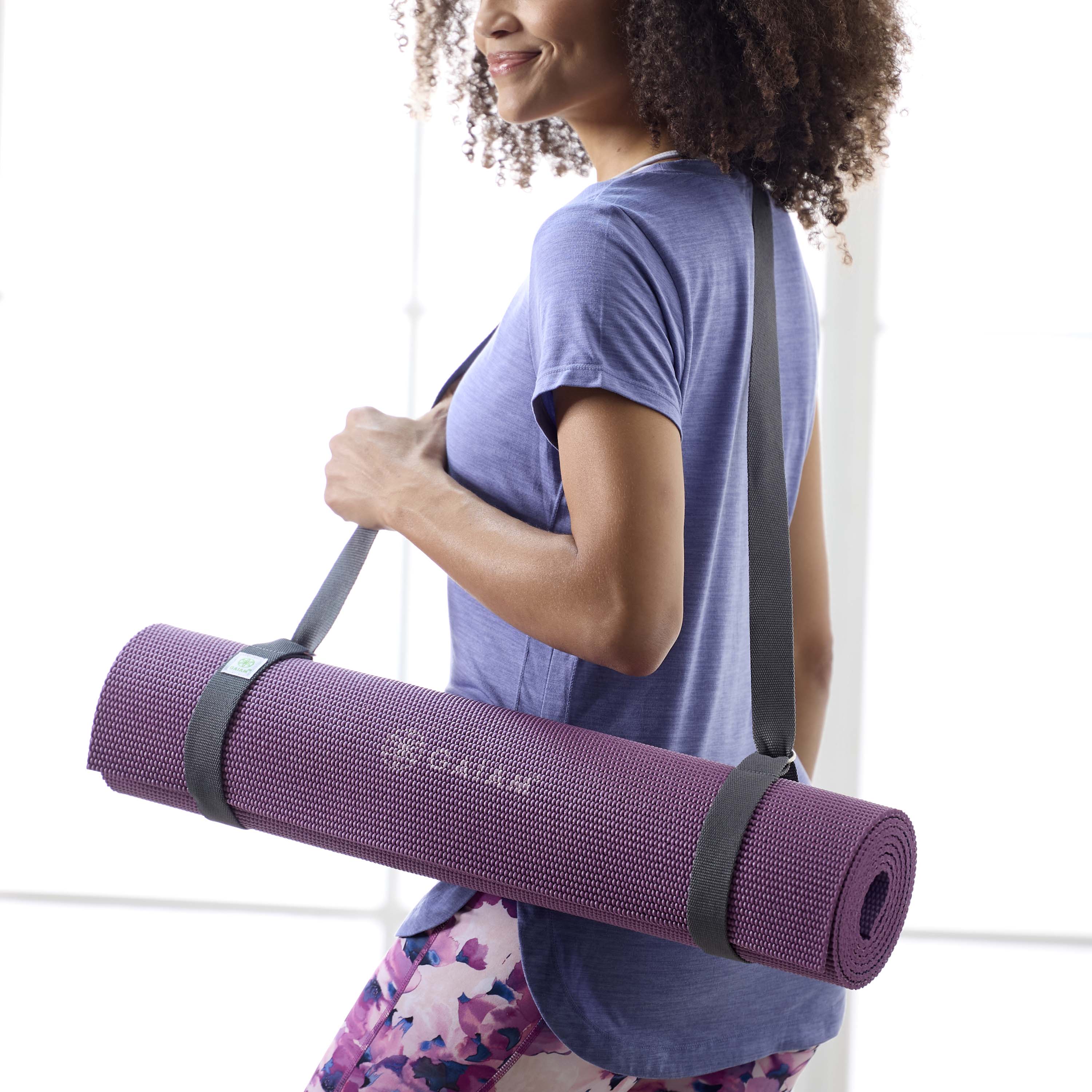 Person carrying a mat with the Gaiam Easy-Cinch Yoga Sling